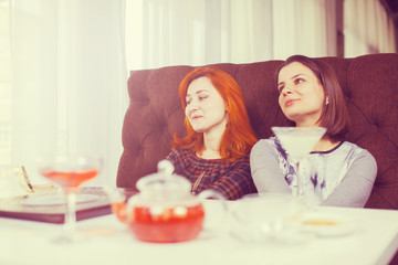 Two beautiful women drinking tea.