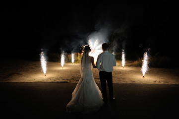 Bride and groom on the background of wedding fireworks