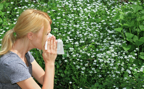 Pollen Allergy, Springtime. Woman Sneezing In A Tissue