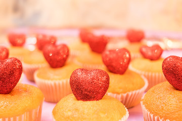 Muffins top view with sparkling red hearts side view toned selective focus