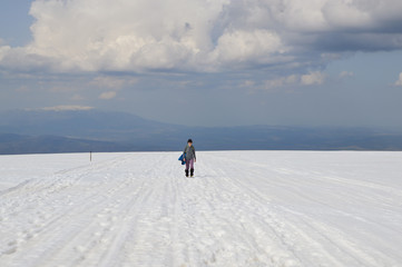 Fototapeta na wymiar Woman on snowy mountain plateau, Rila Mountains, Bulgaria