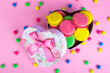 Sweet beautiful French macaroon biscuits on bright multicolored background.