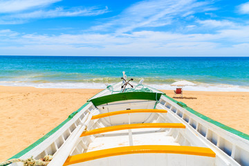 Colorful typical fishing boat on beach in Armacao de Pera coastal village, Portugal