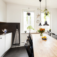 köksinteriör med mörkt golv och kakel med bord vid fönstret