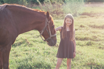 Girl stroking her horse and looking at the camera