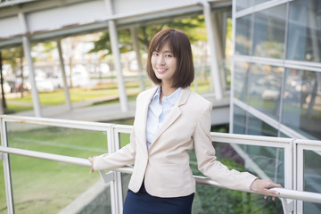 Attractive asian business woman smiling outside office