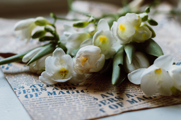 international women's day 8 march card. white flowers bouquet on neutral background. wooden white and vintage newspaper background. rustic style decoration