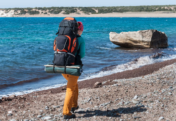 Girl walking on the beach with backpack