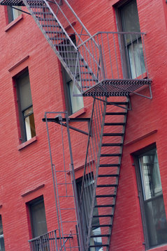 Red painted tenement block and fire escapes, New York