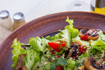 vegetable salad - cold appetizer of fried mushrooms with lettuce and tomatoes
