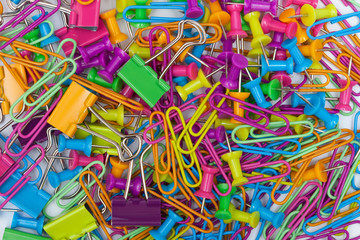 Colorful office supplies - thumb tacks, paper clips and paper clamps