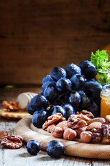Wooden dish with appetizers to red wine, selective focus