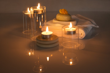 Lighted candles with towels and soap with a flower SPA concept