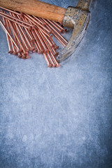 Set of copper construction nails vintage claw hammer on metallic