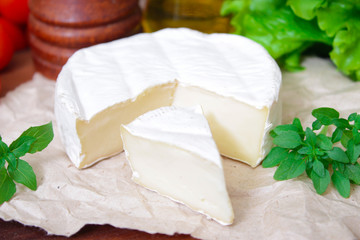 Brie cheese. Camembert cheese. Fresh Brie or Camembert cheese with basil leaves. Italian, French and Mediterranean ingredients.