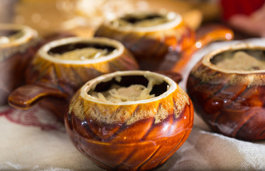 Ceramic pots for roasting on a kitchen table