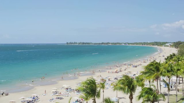 Isla Verde Beach in Puerto Rico. Tourist destination with beach resort and cruise ship tourists, Unrecognizable people enjoying beach summer holiday vacation on caribbean travel. Time lapse.