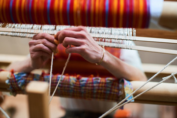 Hands engaged in production of handicraft textiles on the loom