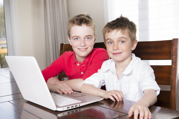 happy children boys looking at laptop indoors