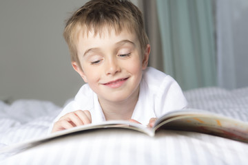little boy reading before dream in his bed