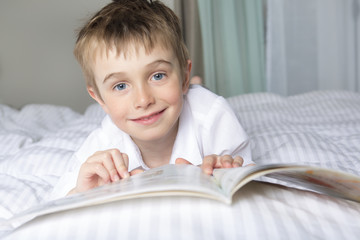 little boy reading before dream in his bed