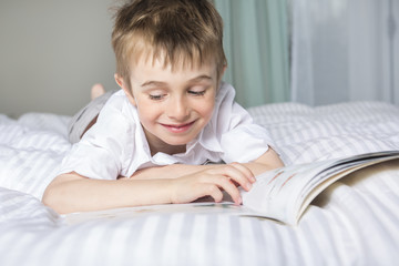 little boy reading before dream in his bed