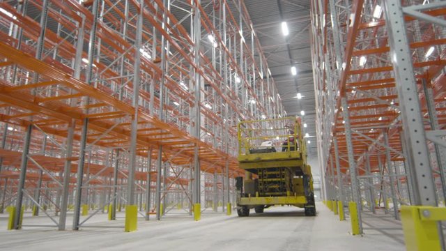 team of installers with hard hats on Scissor Lift working inside a new modern warehouse