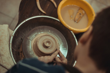child working on potter's wheel