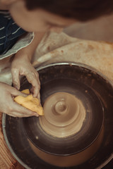 child working on potter's wheel