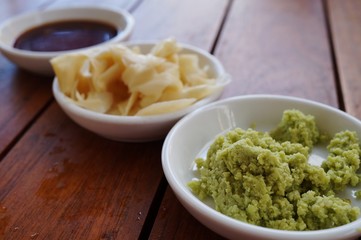 Dishes of green wasabi, pickled ginger and soy sauce Japanese condiments