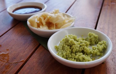 Dishes of green wasabi, pickled ginger and soy sauce Japanese condiments