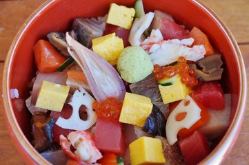Bowl of chirashi sushi with mixed raw fish and salmon roe over rice