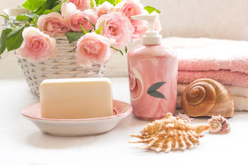 Obraz na płótnie Canvas Pink roses, soap, towels and seashells arrangement