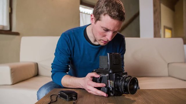 Person looking through retro camera on table