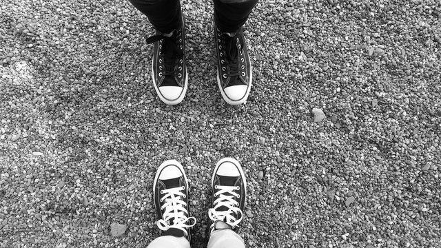 Pair of legs in black and white sneakers