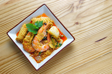 Thai Prawn Curry - King prawns in red curry sauce and coconut milk on wood table