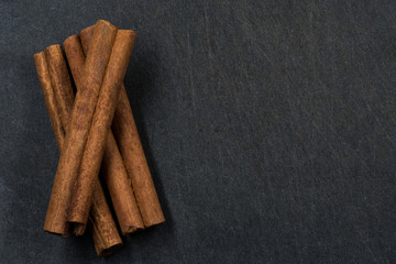 Three Cinnamon Sticks on Black Background with Copy Space to Rig