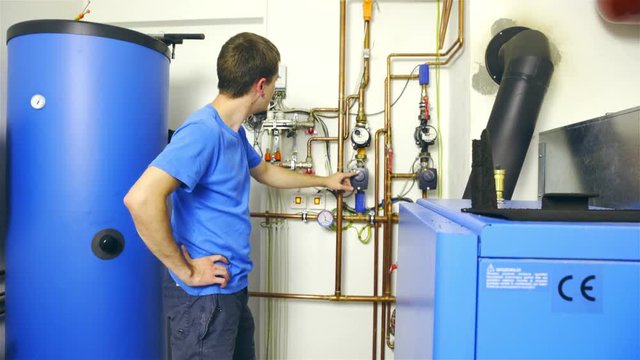 Man checking water boiler pipe system