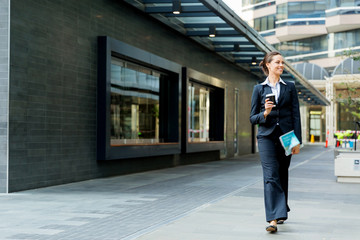 Fototapeta na wymiar Portrait of business woman walking and smiling outdoor