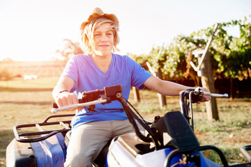 Obraz premium Boy riding farm truck in vineyard