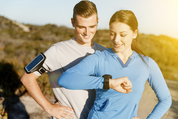 Runner woman with heart rate monitor running on beach