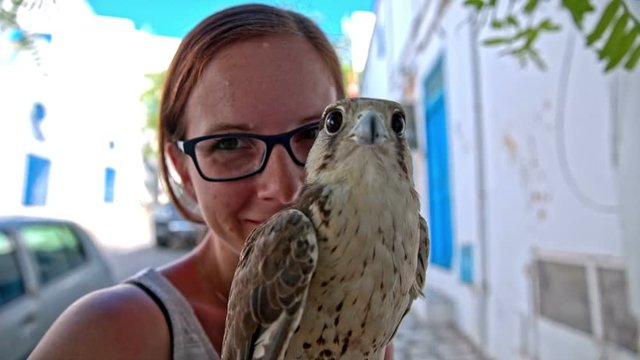 Girl posing with saker falcon hawk close up