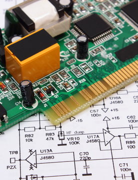 Printed circuit board lying on diagram of electronics, technology