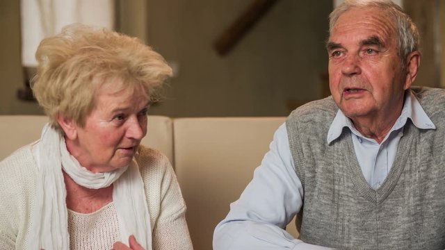 Senior couple on sofa have a discussion