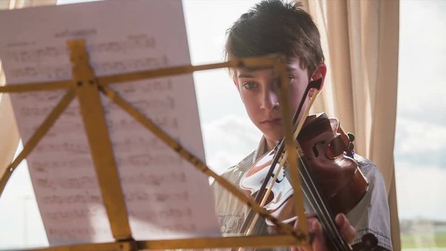 Boy with violin focused on notes