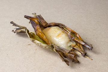 Sticky Rice with Coconut Milk and Taro in banana leaf on wood table (Thai dessert)