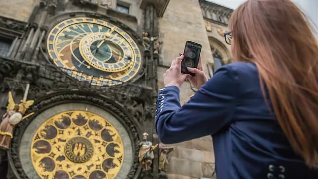 Woman photographing Prague astronomical clock