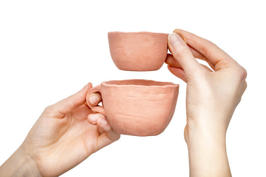 Two clay cups in  woman's hands