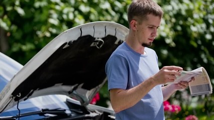 Man checking manual how to fix car problem