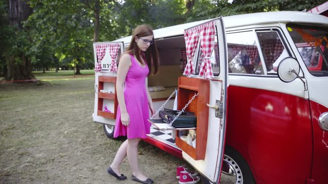 Woman in dress checking a camper van